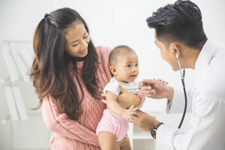 Baby assessed by doctor during development screening at Singapore GP clinic.