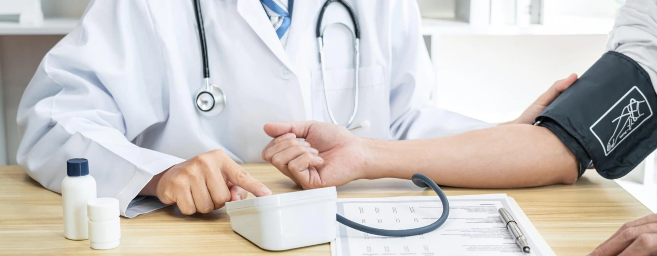 Doctor taking the blood pressure of patient during consultation.