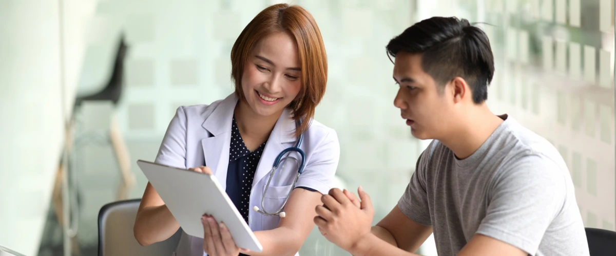 Doctor going through and explaining the health screening results to her male patient.