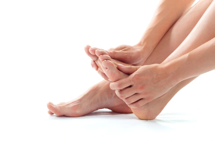 Person sitting down and applying pressure to heel due to pain felt inside it.